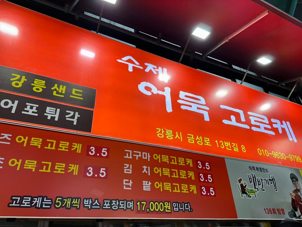 A sign reading “Handmade Fish Cake Croquettes” on a red background