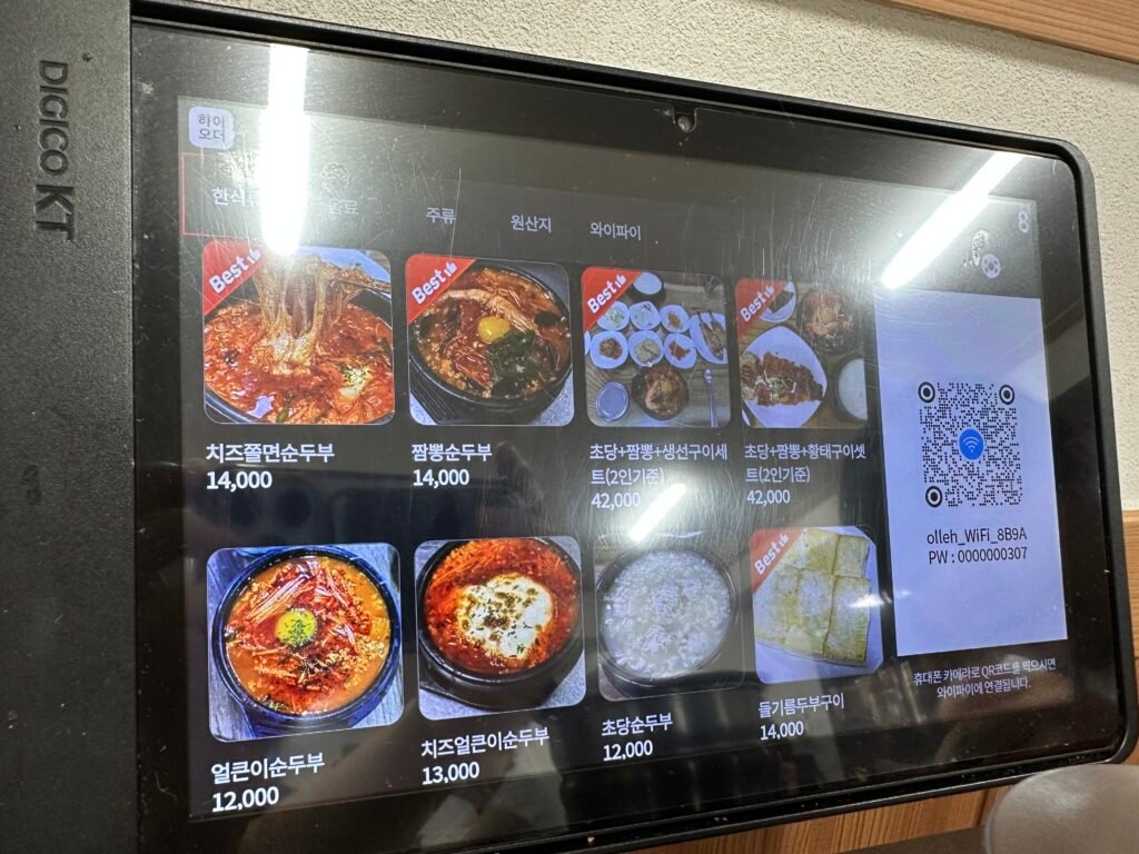 Kiosk menu showing Cheese Jjolmyeon Sundubu and Jjamppong Sundubu priced at 14,000 KRW