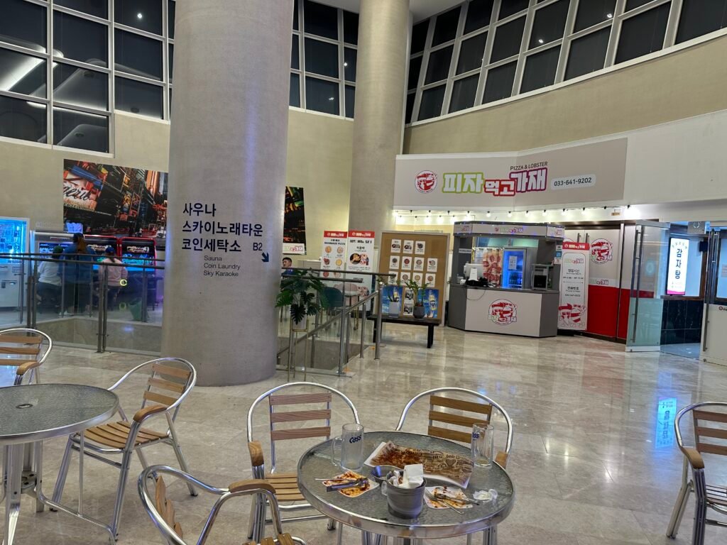 Several tables and chairs with a pizza restaurant visible across the way