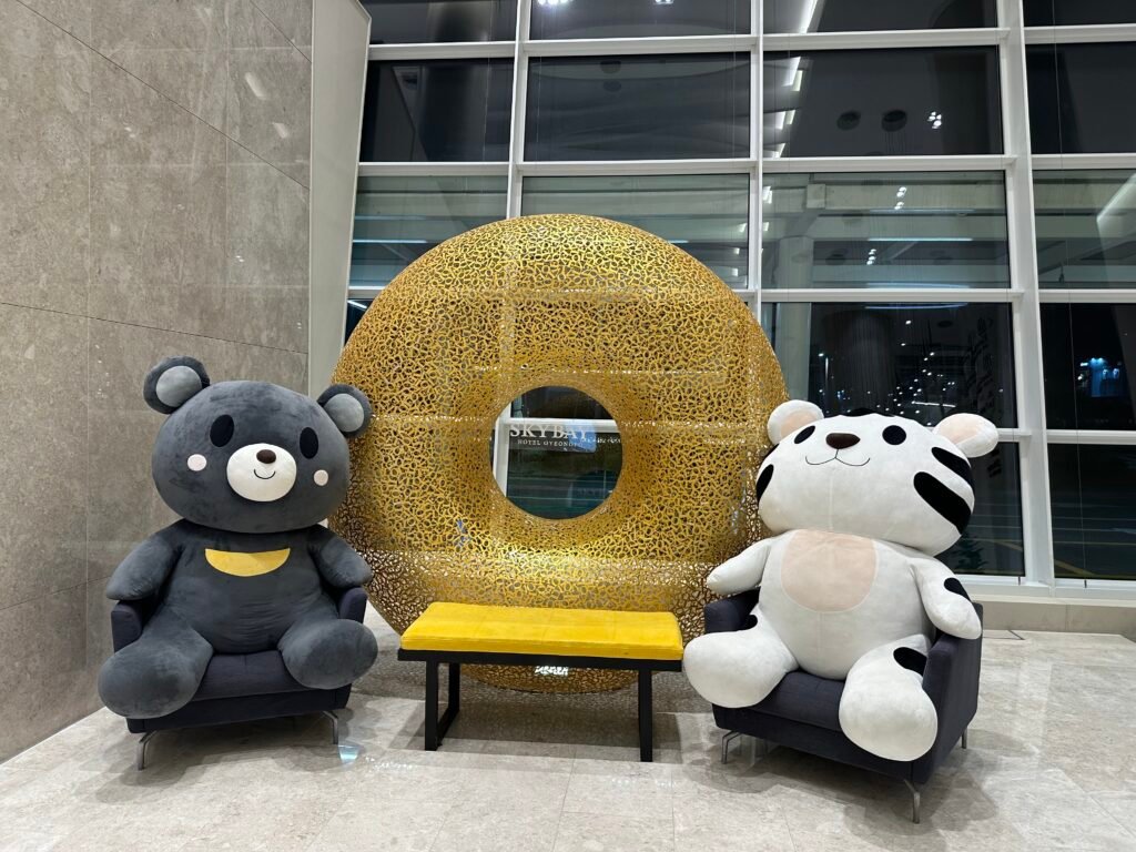 A photo zone featuring bear and white tiger dolls, with a golden donut display in the center