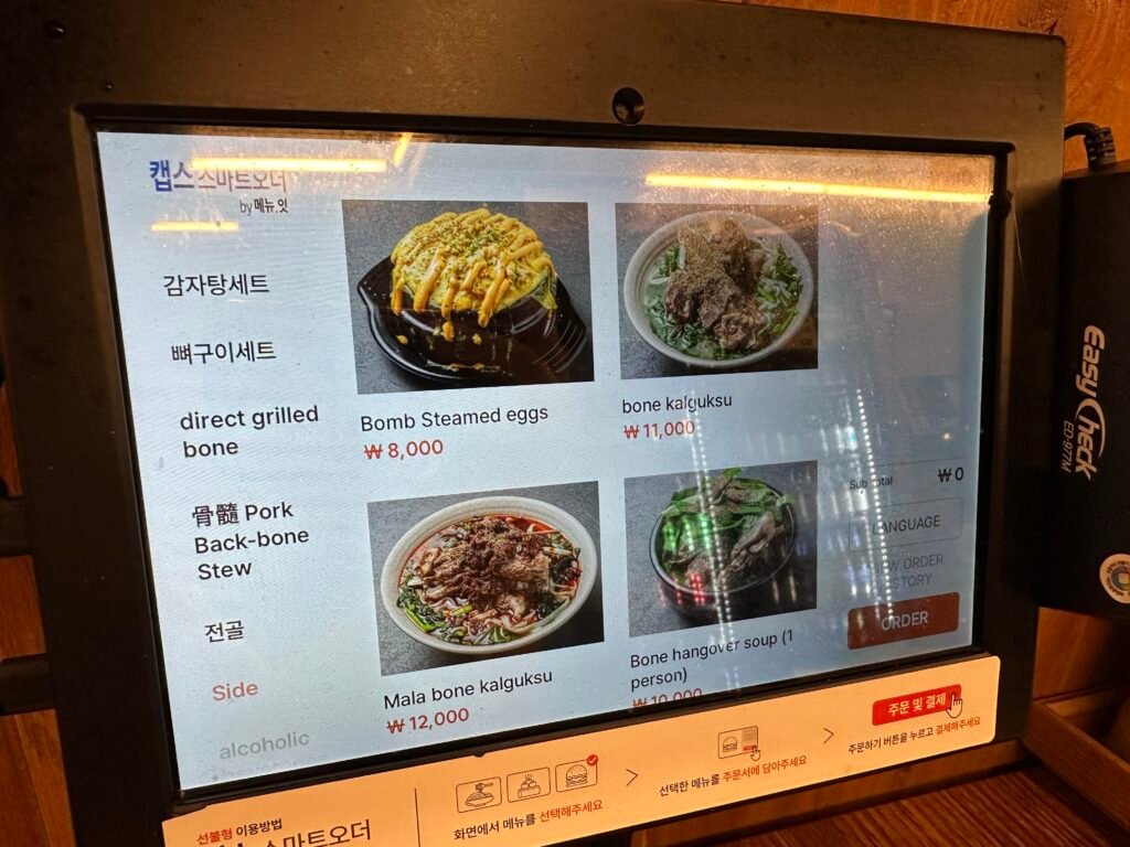 A touchscreen ordering kiosk displaying the menu in English.