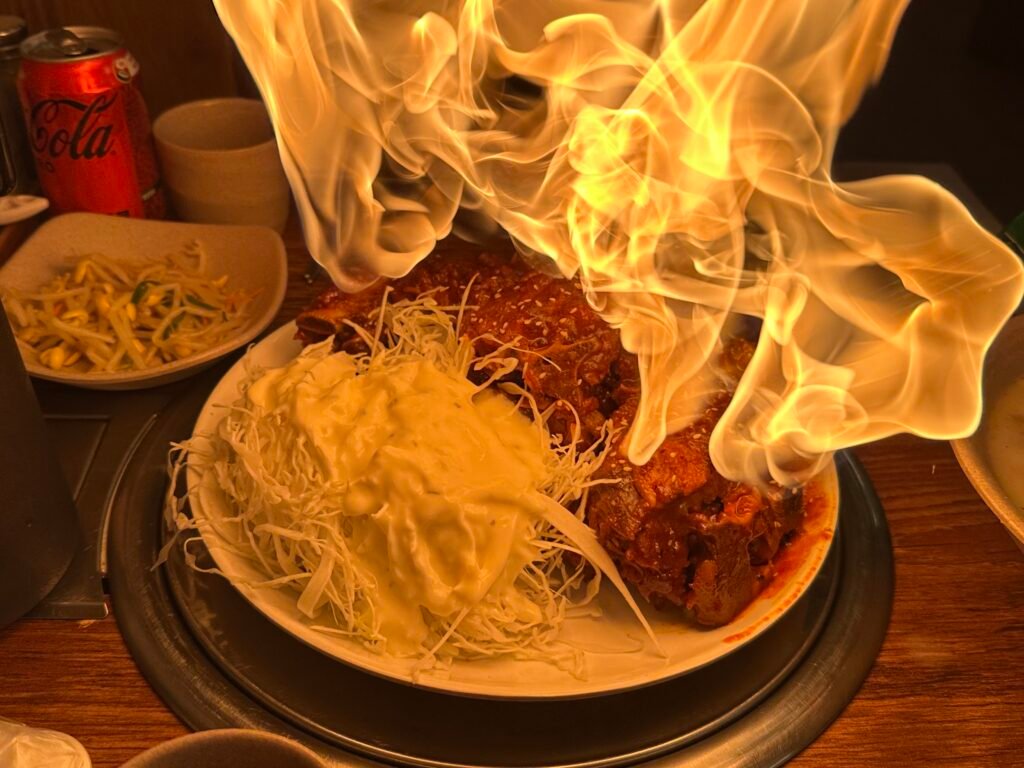 A staff member torching the grilled pork spine to add a smoky finish.