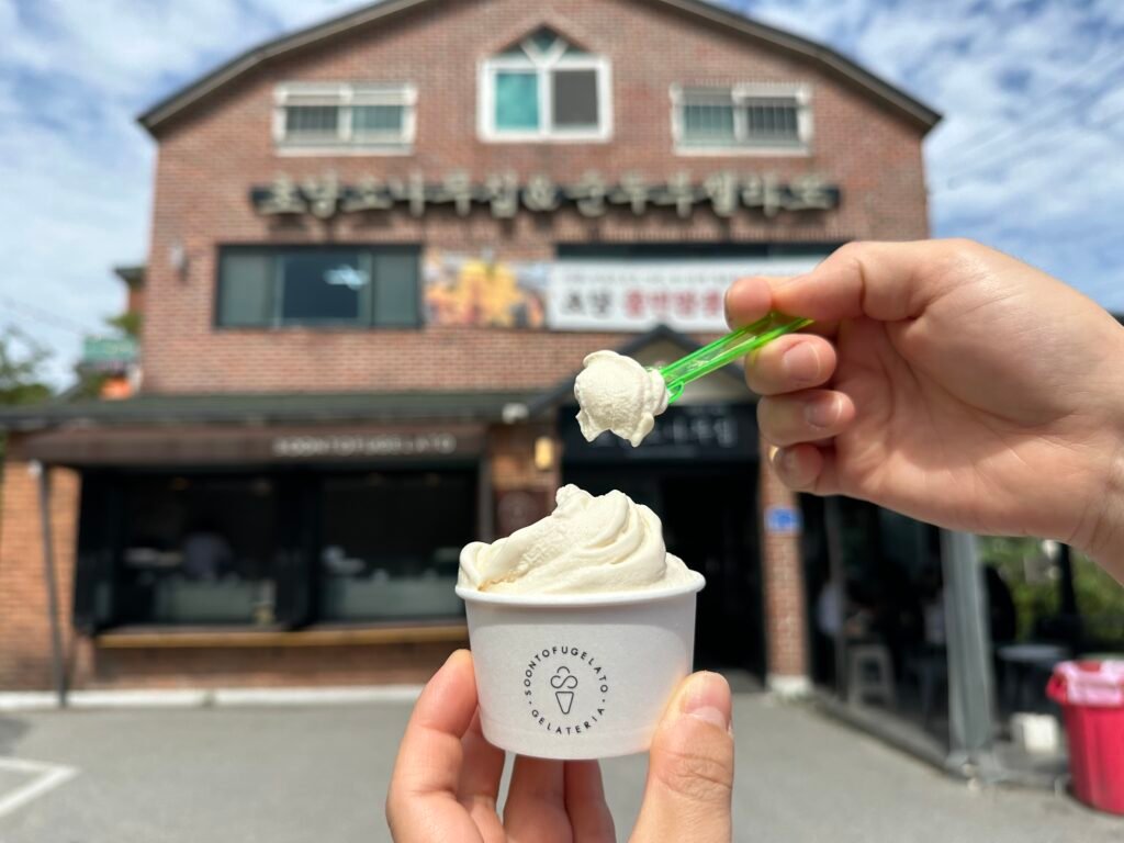 Sundubu gelato from Chodang Sonamujip with a spoonful lifted in front of the shop