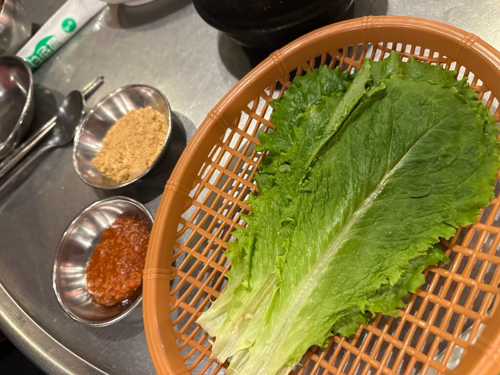 Fresh green lettuce with ssamjang and soybean powder served as side condiments